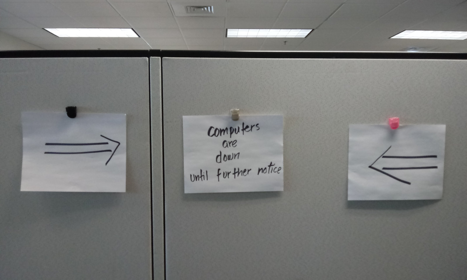 A sign hanging on a cubicle announcing that the computer network was down