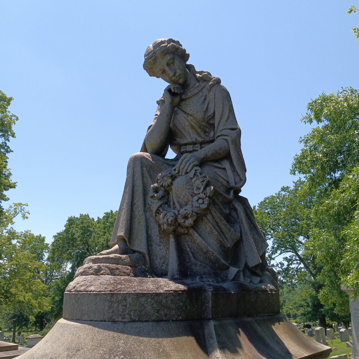 Sculpture atop the grave of Erastus and Josephine McCleary of a woman downcast, holding a wreath