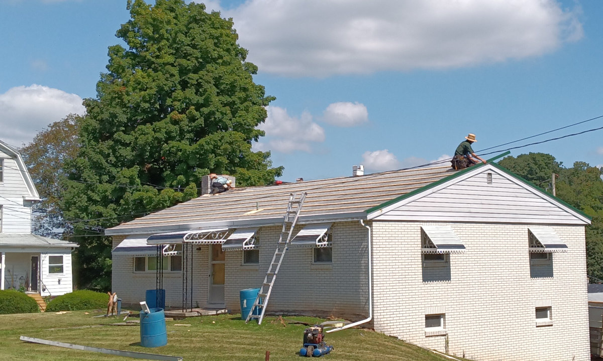 Two Amish boys reroofing a house