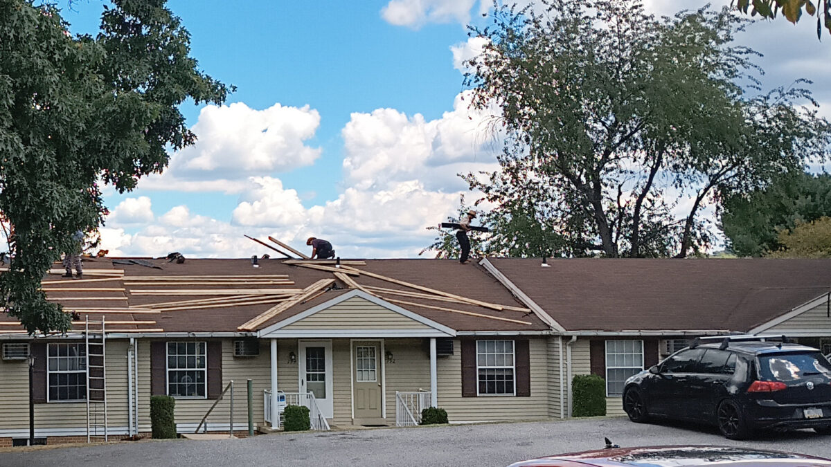 An Amish roofing crew, working on installing a metal roof in my complex. The view from my apartment's front door.