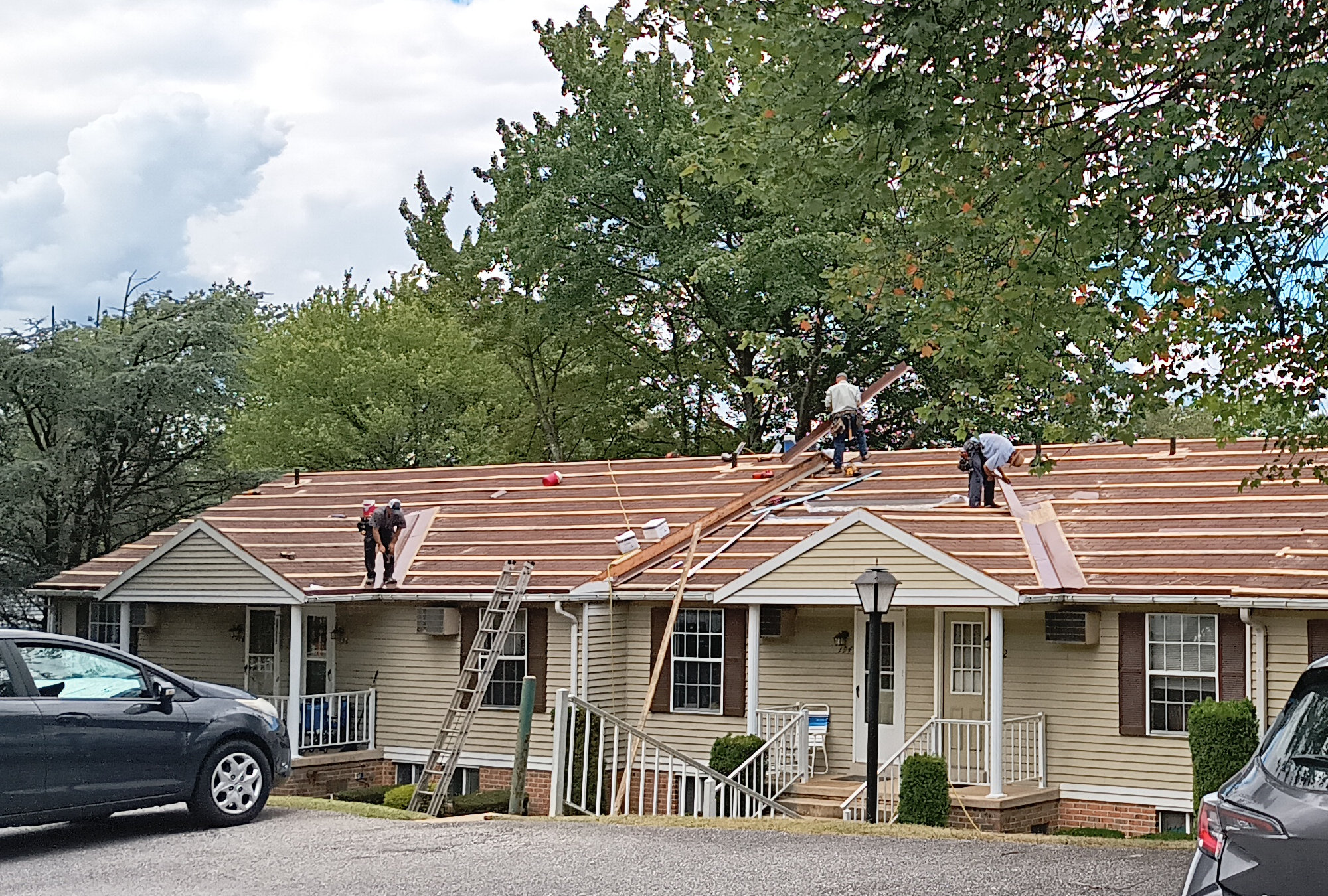 An Amish roofing crew, working on installing a metal roof in my complex. Another view, this one with a better angle.