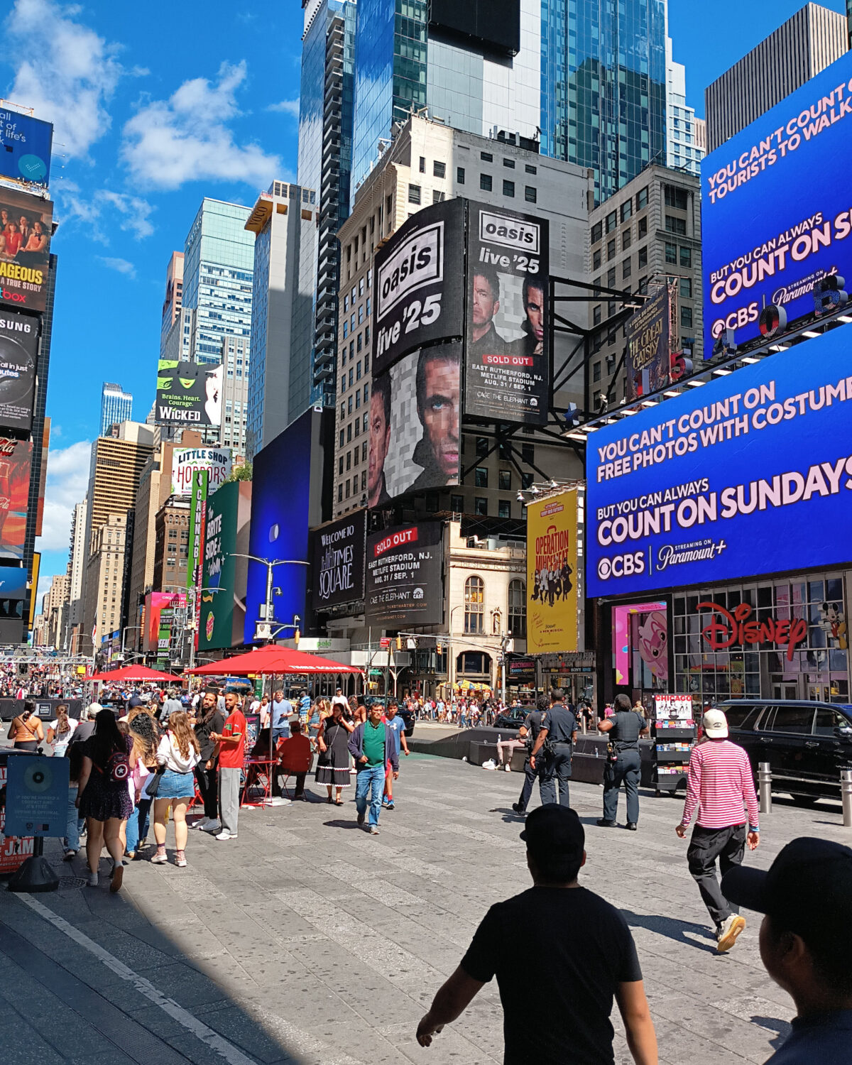 Times Square, in all of its garish excess. One of the video billboards is advertising the Oasis show.