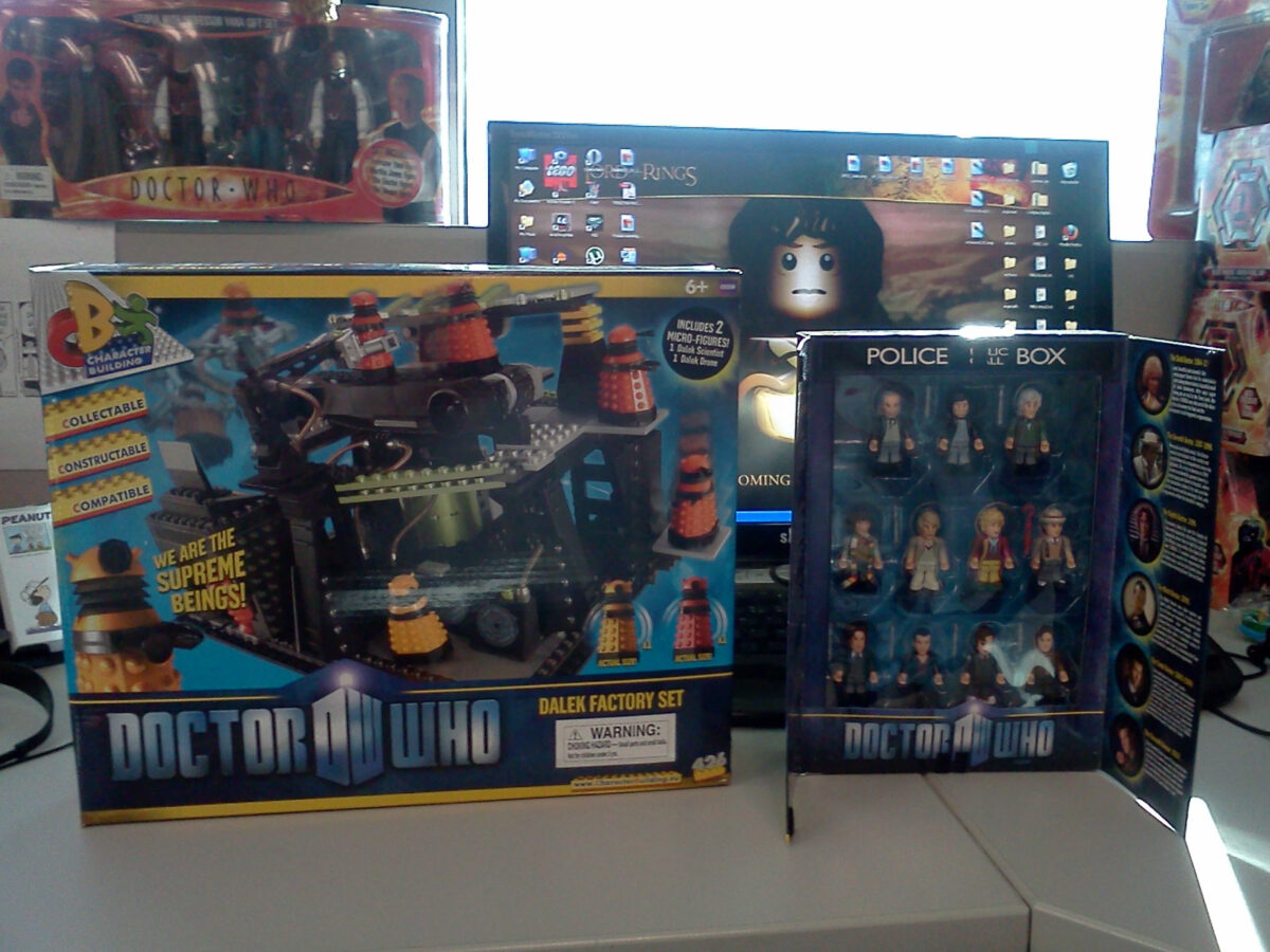 My desk at Diamond, showing a LEGO Lord of the Rings wallpaper on my computer and Doctor Who not-LEGO sets on my desk.