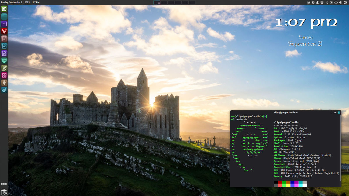Desktop screenshot of Linux Mint Debian Edition, showing a wallpaper of a ruined castle with the sun rising behind it.