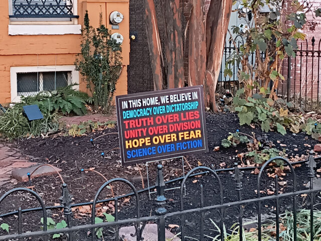 A sign in a yard that reads: In this house we believe in Democracy over Dictatorship, Truth over Lies, Unity over Division, Hope over hear, Science over Fiction.