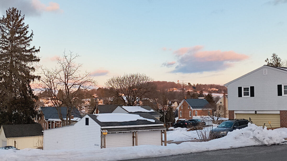 The sun setting on Yoe Hill, with pinkish clouds in the fading sunlight