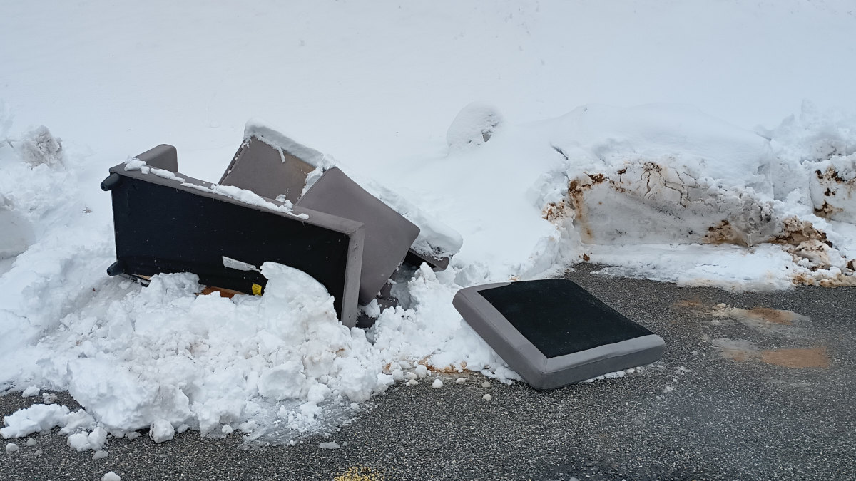 A discarded sectional at the dumpsters that got caught up in the snow plow